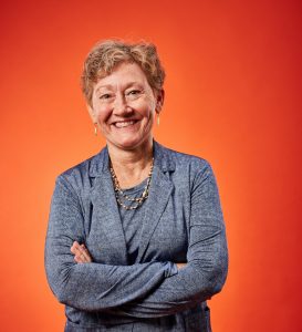 Claire Wyneken headshot, orange background