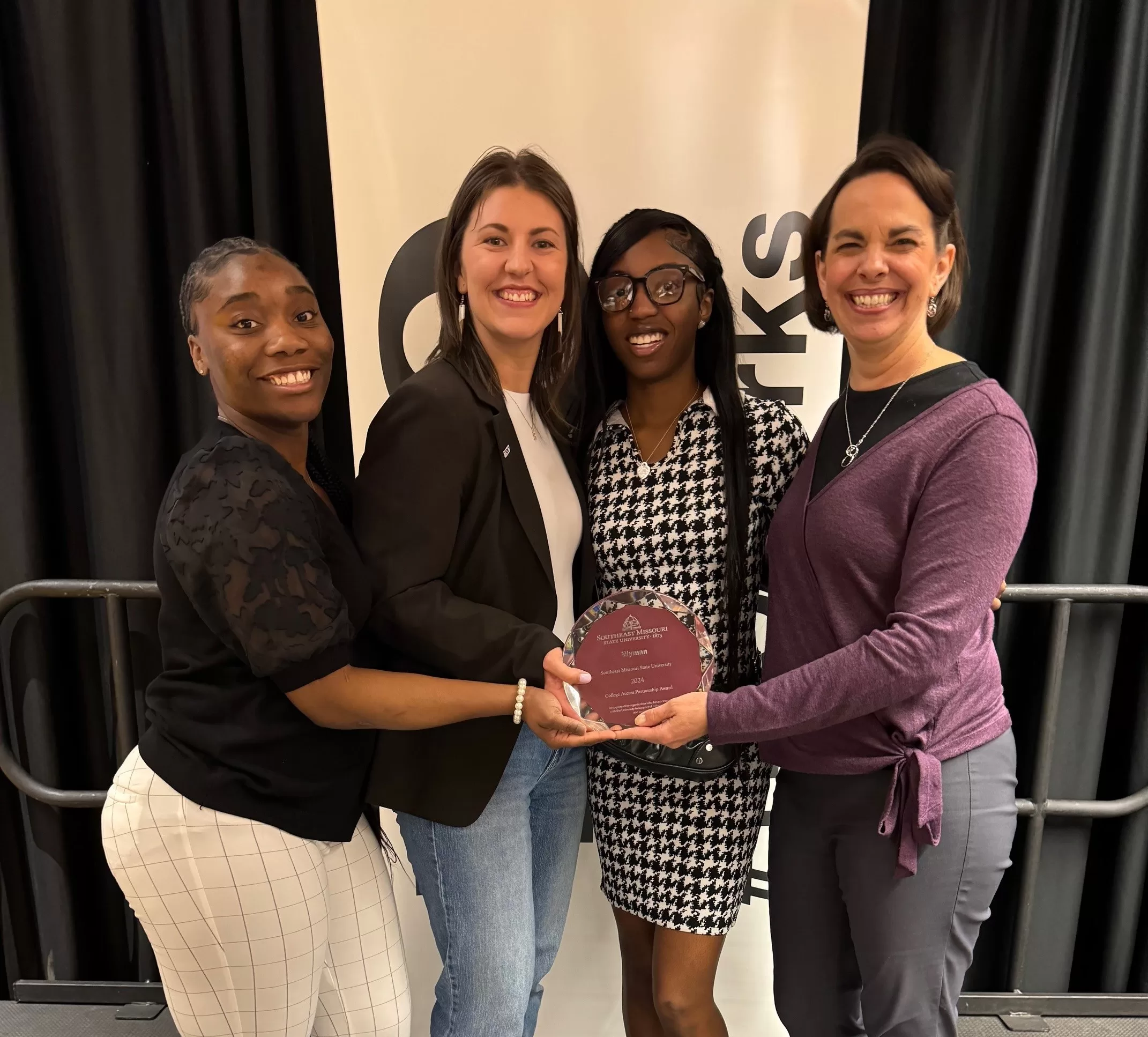 group of people accepting an award and smiling at the camera