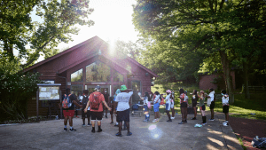 back of young people at camp in front of a rustic building