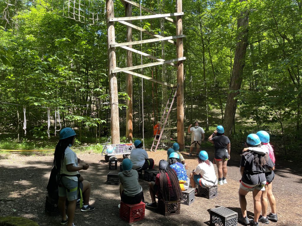 teens at climbing tower at a camp