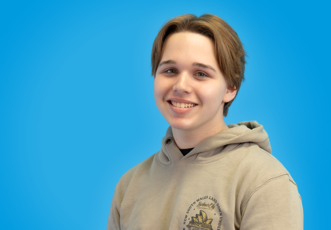 a young man smiles at the camera